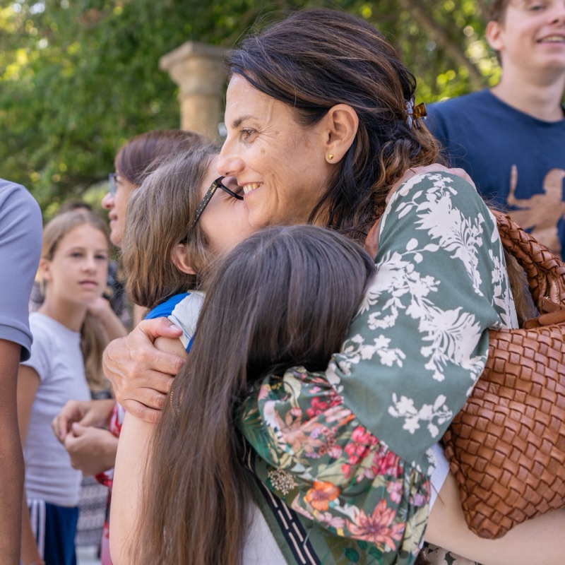 Una madre abraza a su hija al volver