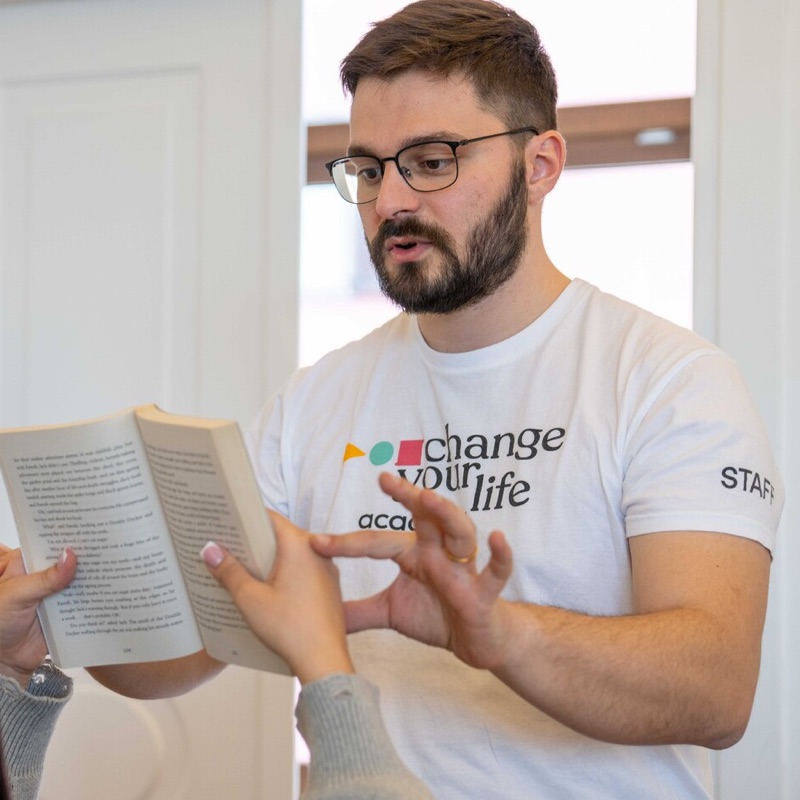 Un tutor explica un pasaje de un libro a una chica