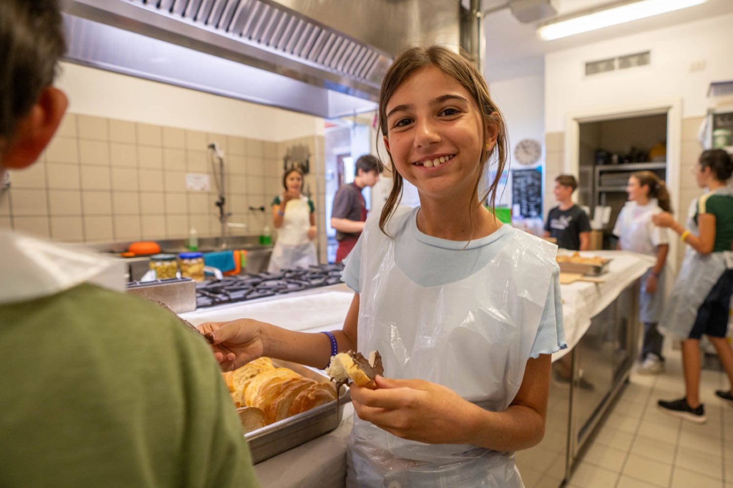 Una ragazza sorridente in cucina con un vassoio