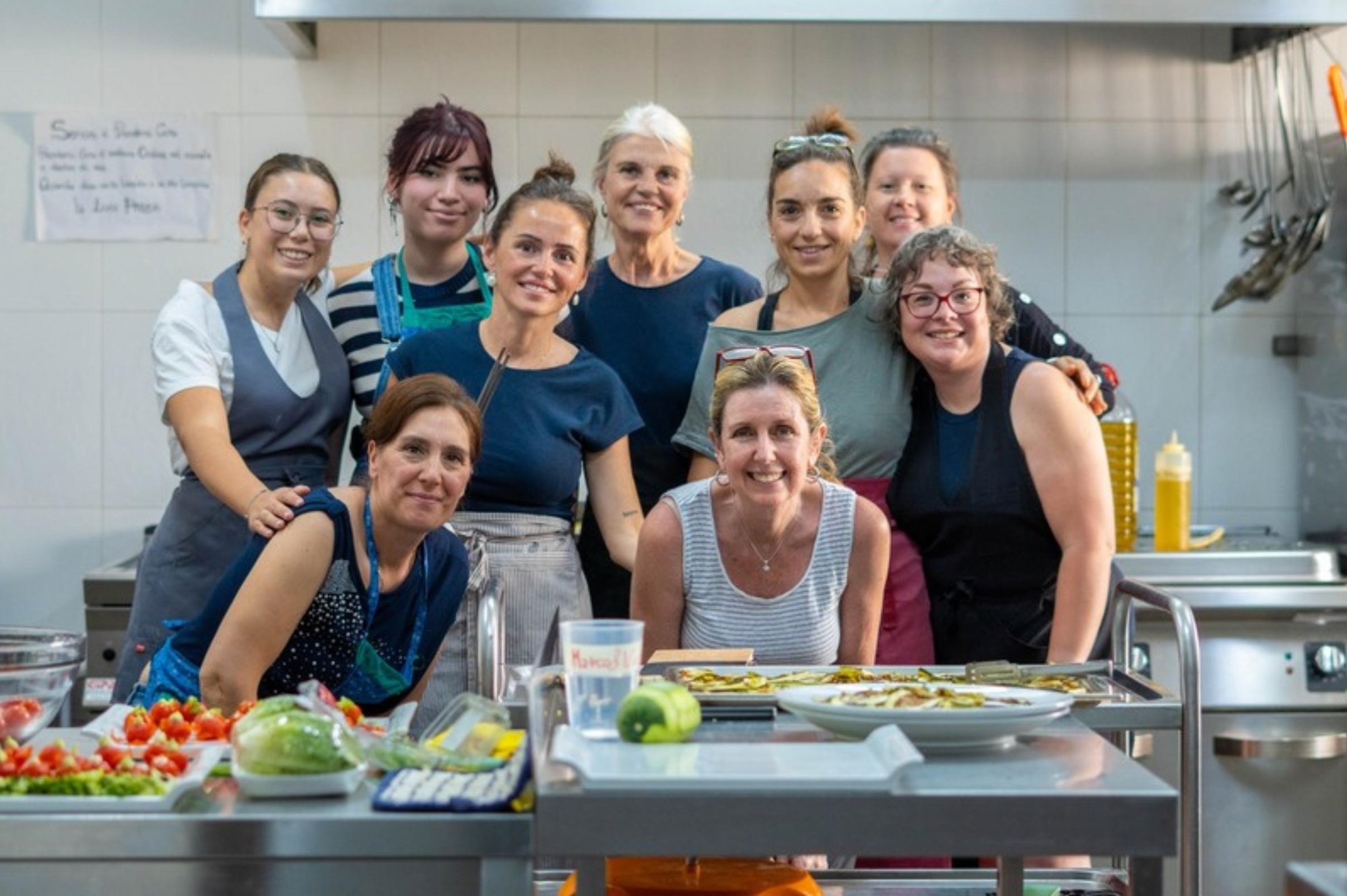 El grupo en la cocina, sonriente, alrededor de la mesa de trabajo