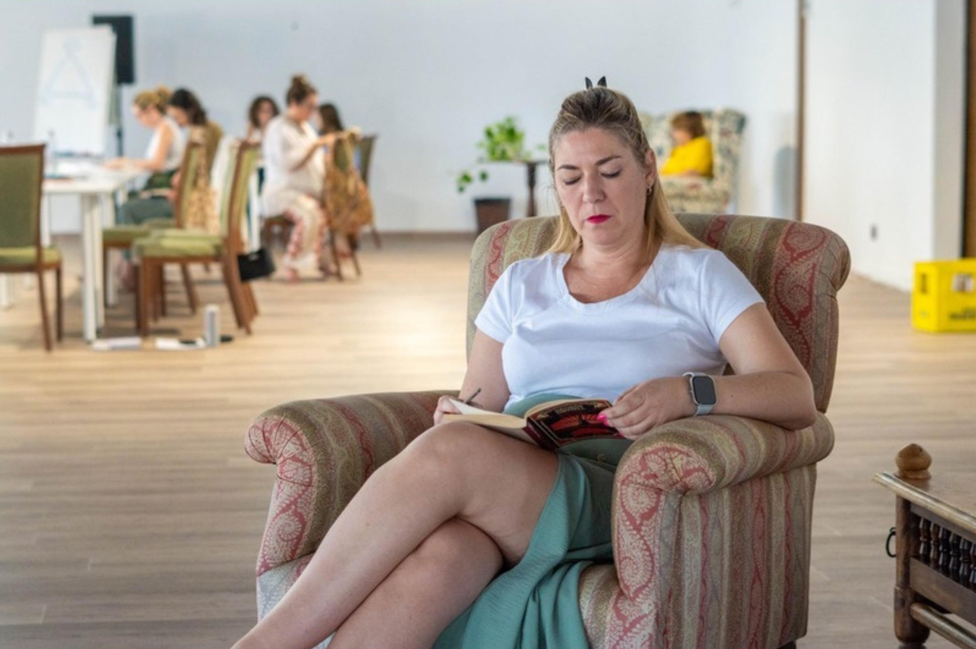El gran salón de la sede, luminoso, con una participante leyendo en un sillón