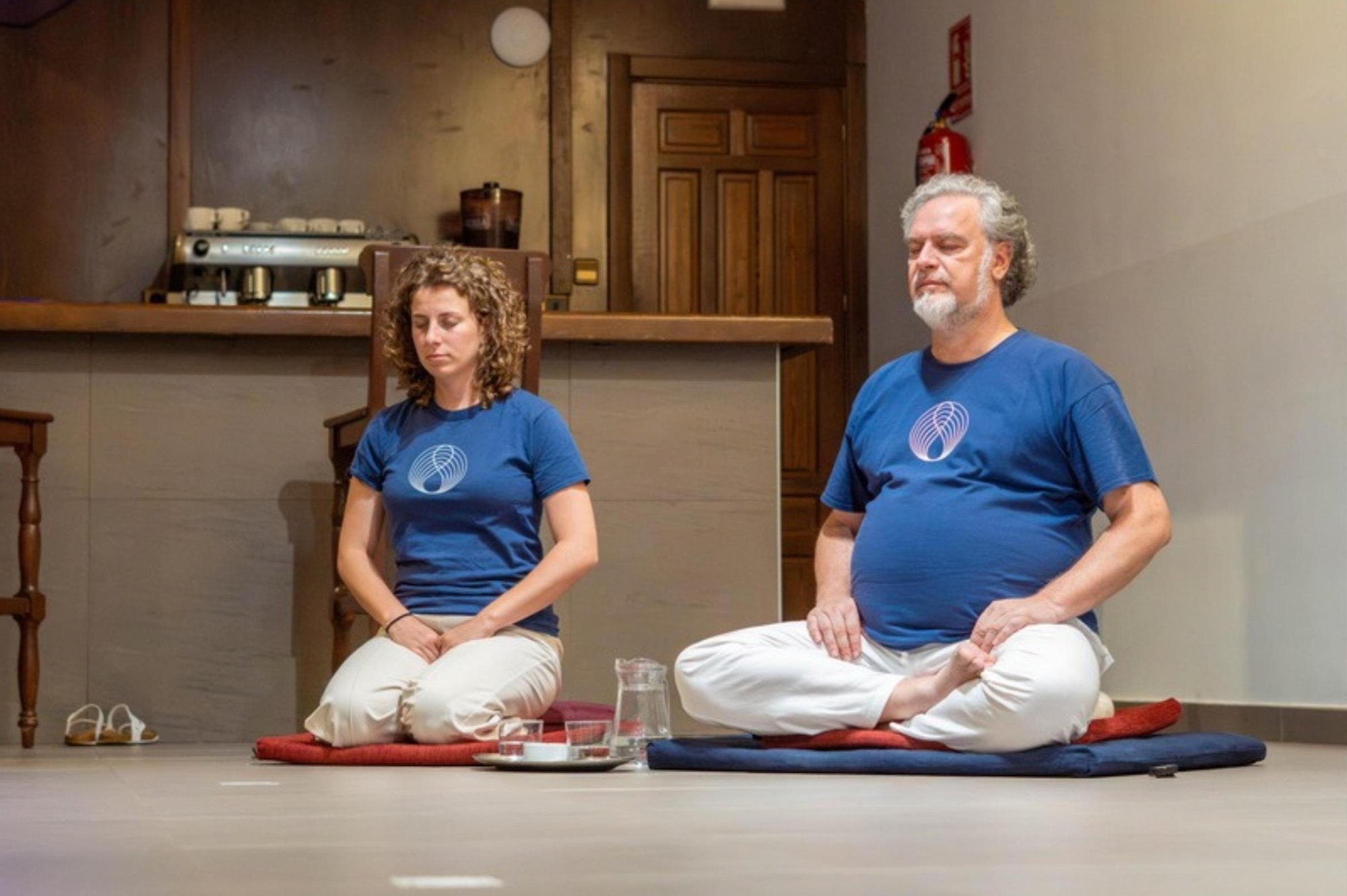 Dos participantes sentados en meditación