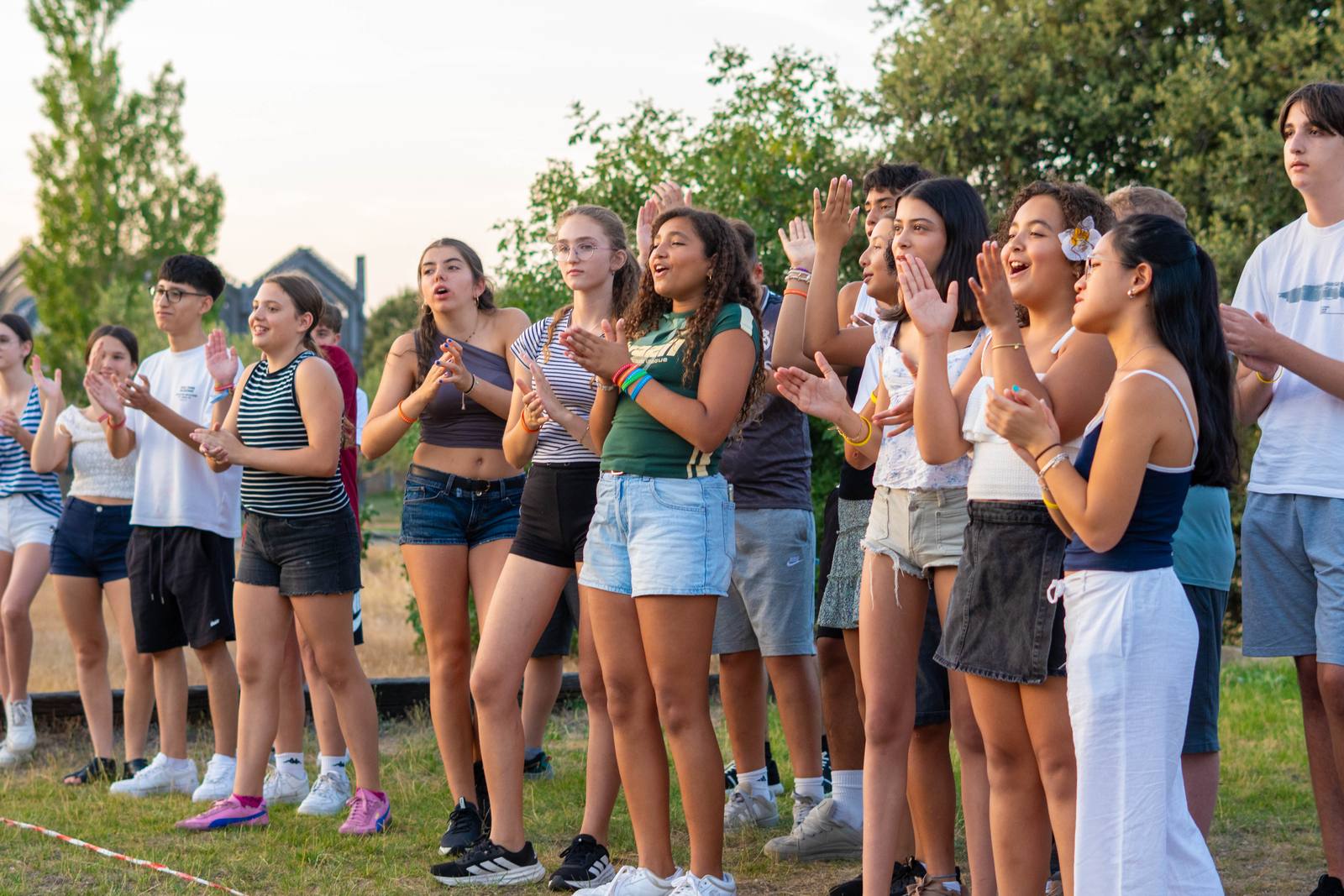 Chicos y chicas aplauden al atardecer en la Finca de la Paz