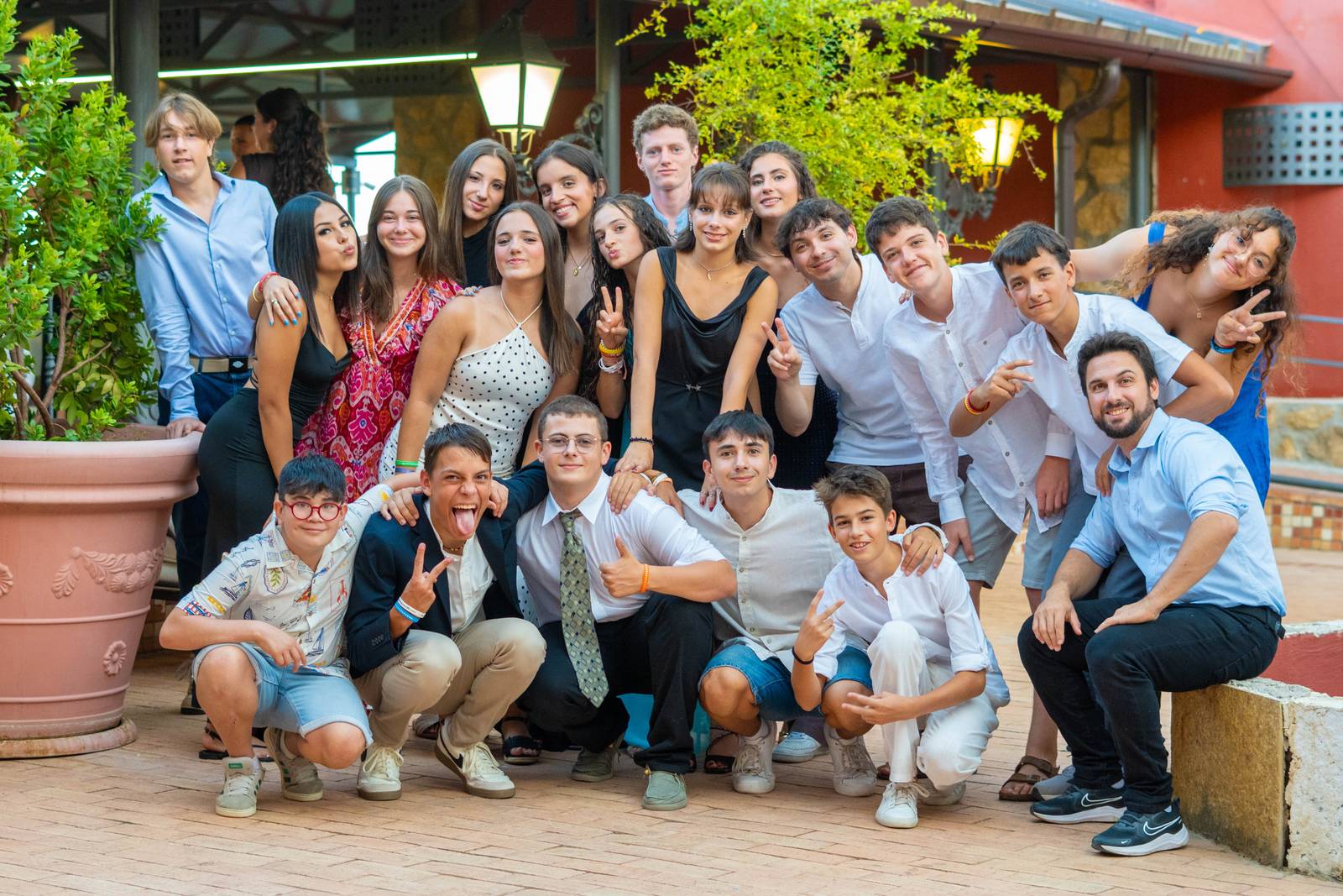 Un grupo grande de chicos, chicas y equipo posa junto en el patio de la finca