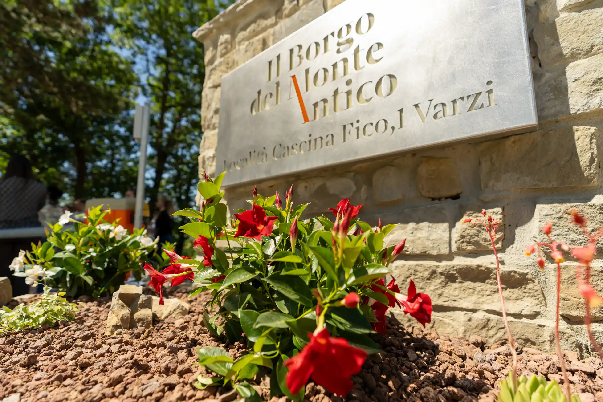 stone-entrance-sign-with-red-flowers