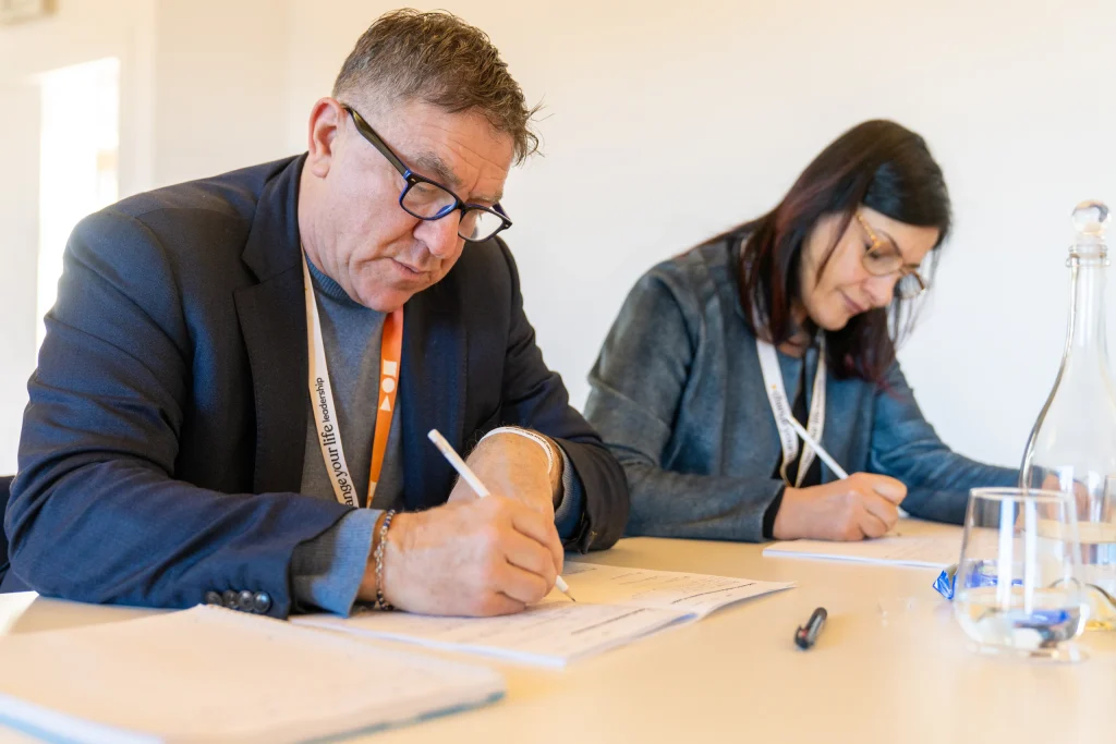 Two participants writing during a seminar