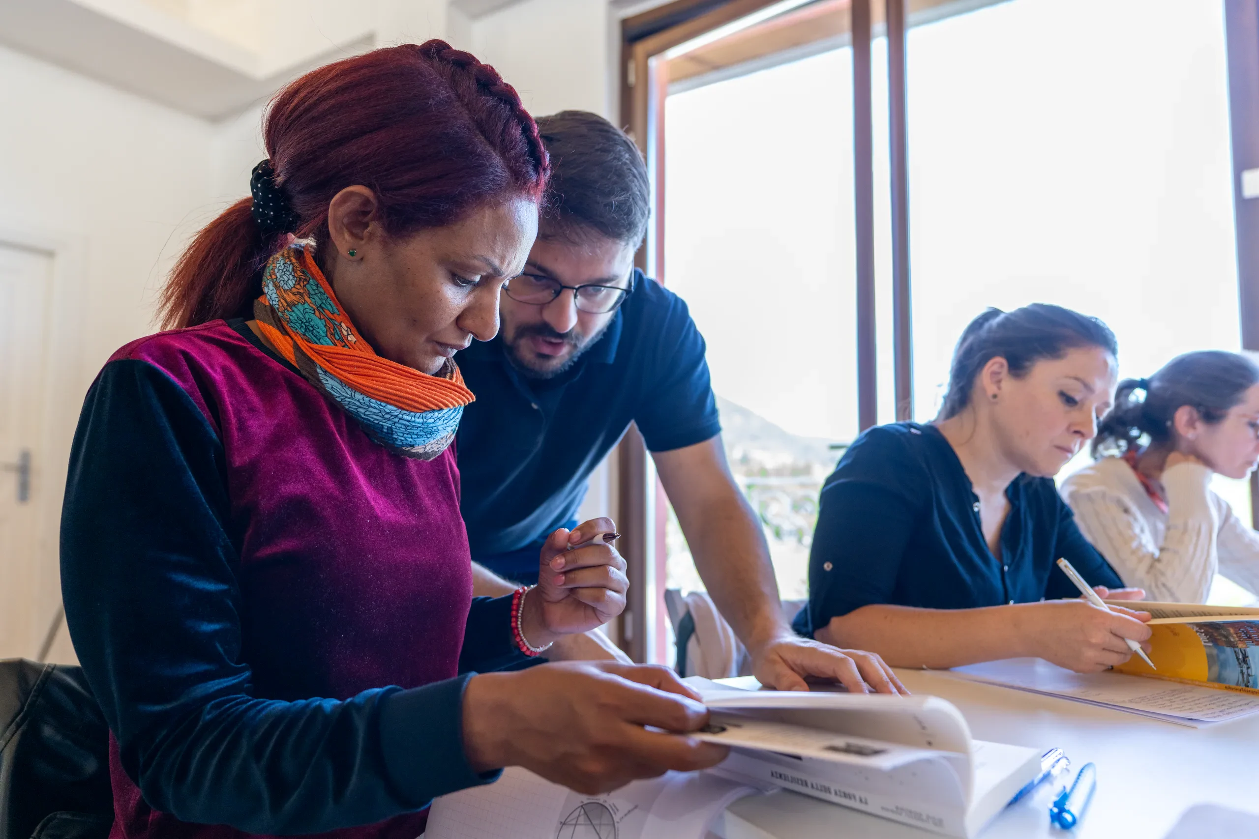 A participant helping another with a book